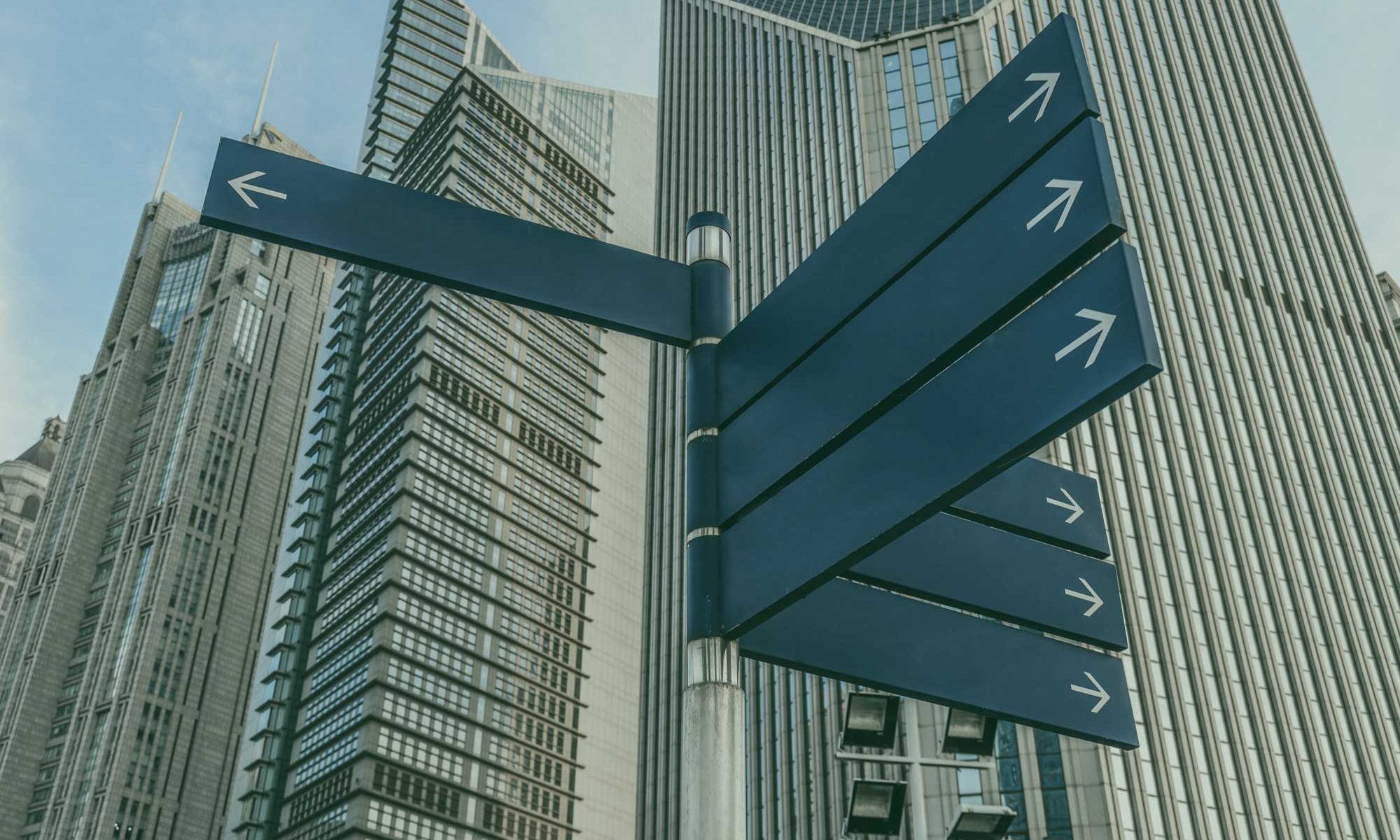 A street sign with arrows pointing in different directions.